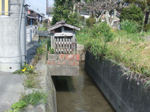 水路に張り出してお参りしている地蔵さん